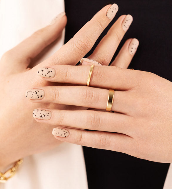 Delicate nails styling adorned with a top coat with black specks