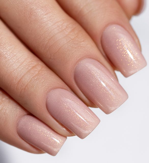 Delicate peach manicure with a touch of shimmering gold
